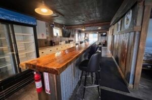 Rustic bar interior at Sunsets Resort Birchwood WI with wooden counter and industrial lighting.