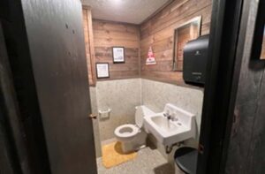 Cozy restroom at Sunsets Resort Birchwood WI with wood-paneled walls and all essentials.